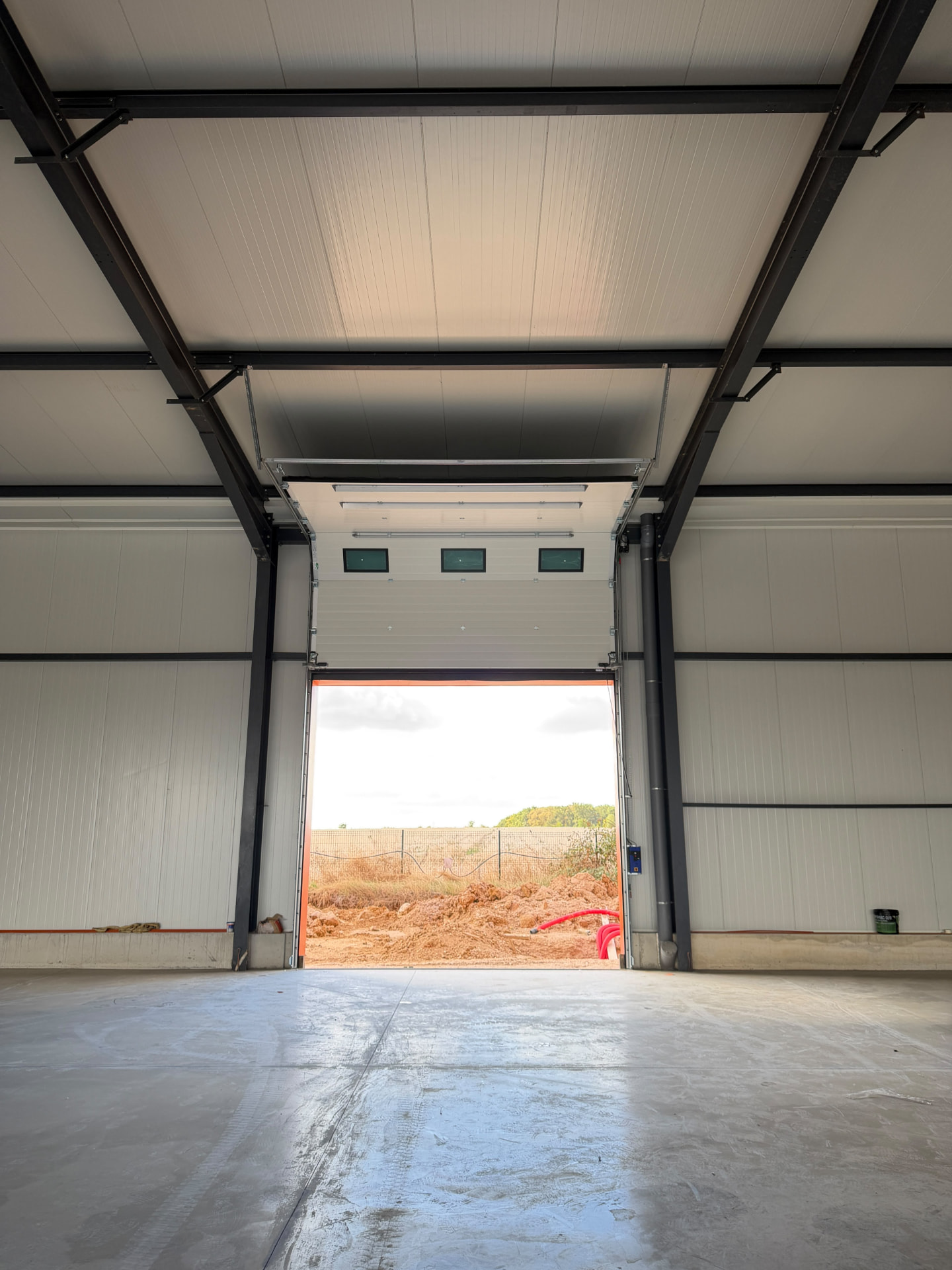 Porte sectionnelle industrielle installée sur un bâtiment professionnel moderne